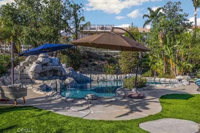 pool with a yard and a patio area