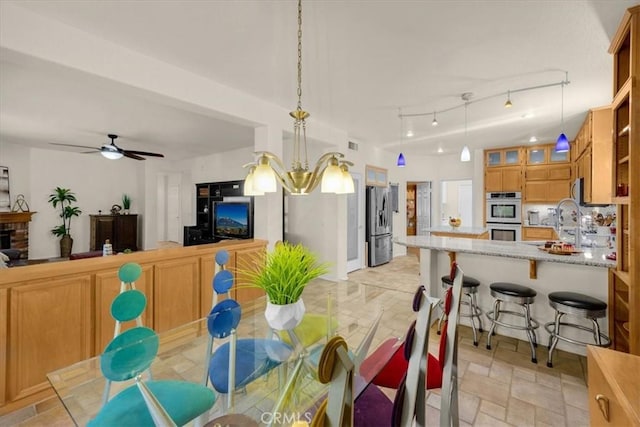 dining room featuring ceiling fan, stone finish floor, and rail lighting