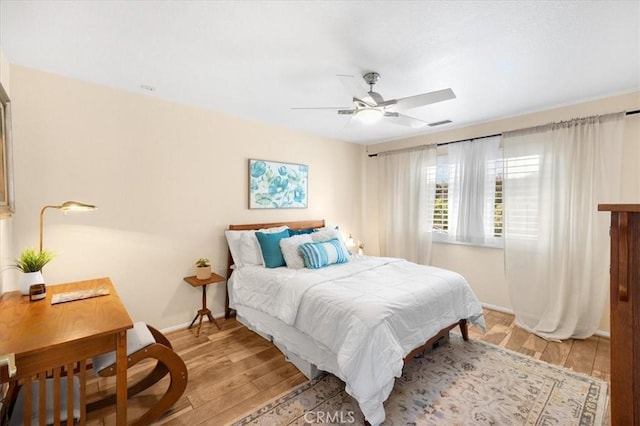 bedroom with light wood-style floors, baseboards, and a ceiling fan