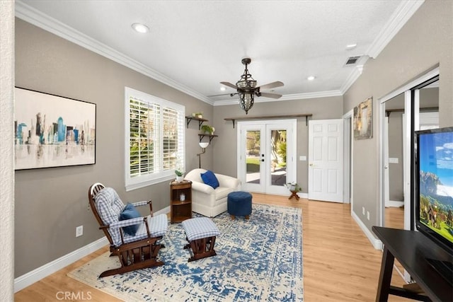 sitting room with french doors, light wood-type flooring, visible vents, ornamental molding, and recessed lighting