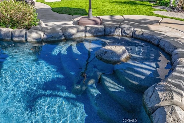 view of swimming pool with a pool and a yard