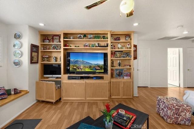 living area with light wood finished floors, ceiling fan, and recessed lighting