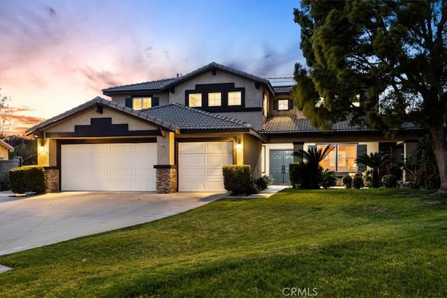 view of front of property with a tile roof, stucco siding, concrete driveway, an attached garage, and a front lawn