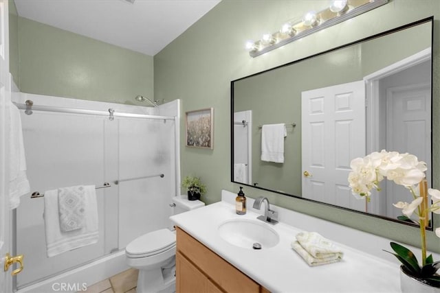 bathroom with toilet, tile patterned flooring, vanity, and a shower with shower door