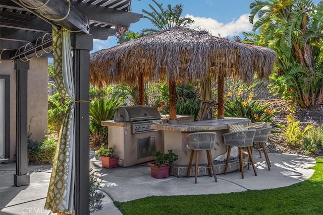 view of patio featuring a grill, a pergola, exterior kitchen, and outdoor wet bar
