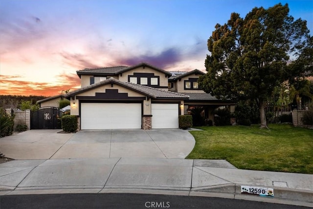 view of front of home featuring a lawn, a garage, stucco siding, concrete driveway, and a gate