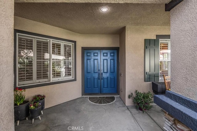 view of exterior entry featuring stucco siding