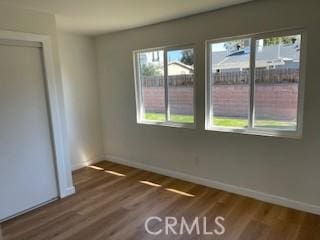 unfurnished room with baseboards and wood finished floors