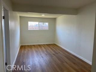 empty room featuring wood finished floors and baseboards