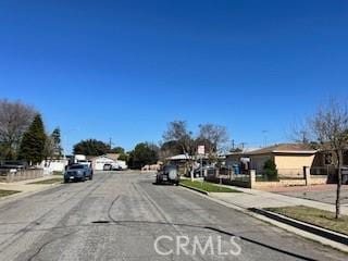 view of street featuring a residential view, curbs, and sidewalks