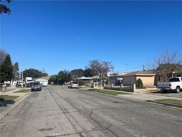 view of street featuring sidewalks, street lights, and curbs