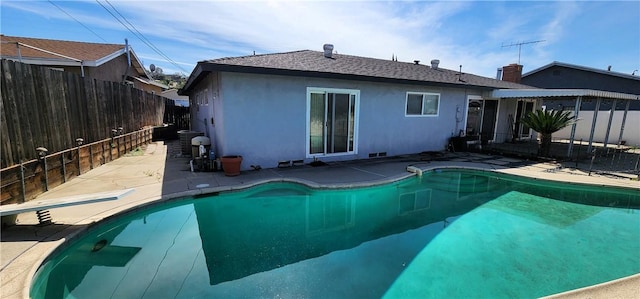 rear view of house featuring a fenced backyard, a fenced in pool, a patio, and stucco siding