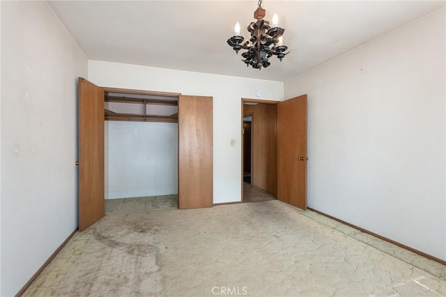 unfurnished bedroom with carpet floors, a closet, baseboards, and an inviting chandelier