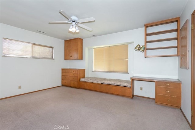 interior space featuring a ceiling fan, light colored carpet, and baseboards