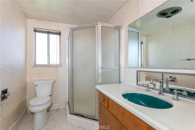 bathroom featuring toilet, vanity, a shower stall, tile patterned floors, and wallpapered walls