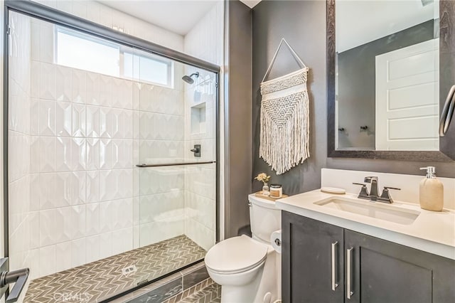 full bath featuring a stall shower, vanity, and toilet