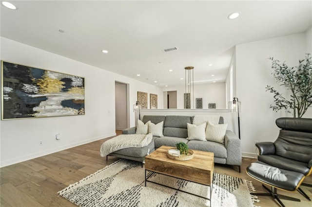 living room with baseboards, visible vents, wood finished floors, and recessed lighting