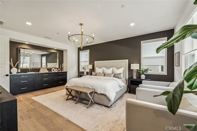 bedroom with light wood-style floors, visible vents, a chandelier, and recessed lighting