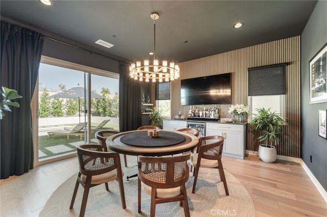 dining room with recessed lighting, a notable chandelier, visible vents, light wood-type flooring, and indoor wet bar