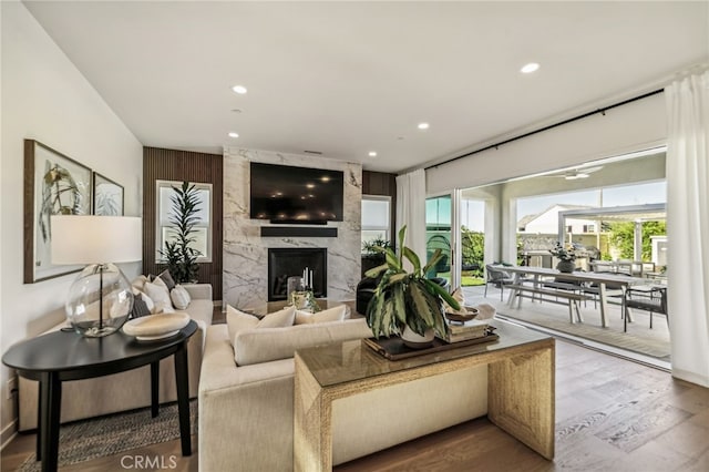 living area with a fireplace, wood finished floors, and recessed lighting