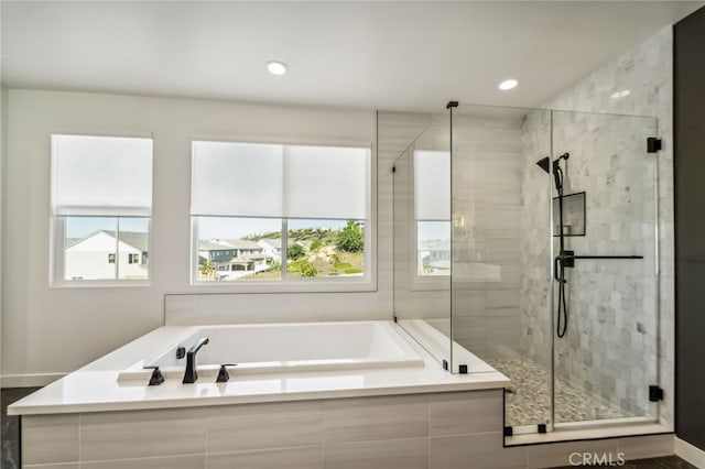 bathroom featuring a shower stall, a bath, and recessed lighting