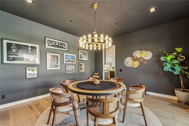 dining room featuring baseboards, recessed lighting, wood finished floors, and a notable chandelier