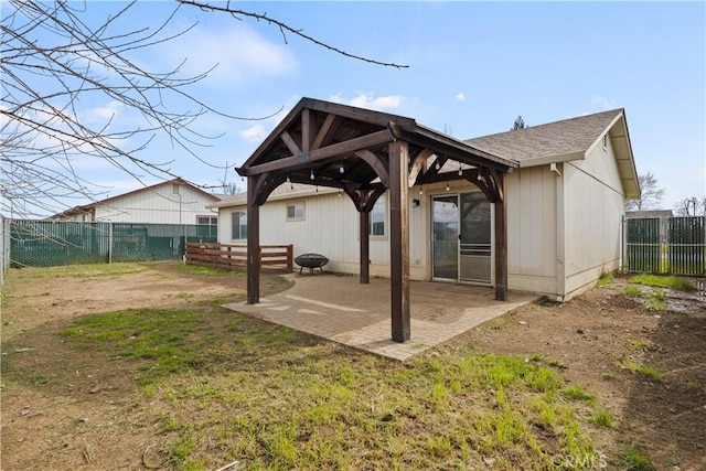 rear view of property featuring a patio, roof with shingles, a gazebo, and a fenced backyard