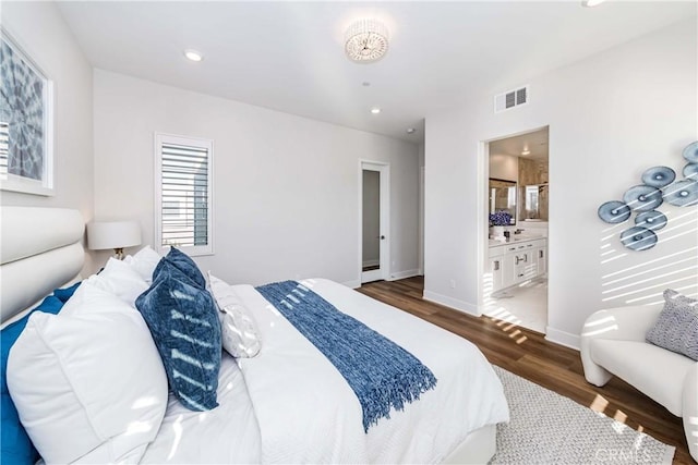 bedroom with dark wood-style flooring, recessed lighting, visible vents, ensuite bathroom, and baseboards