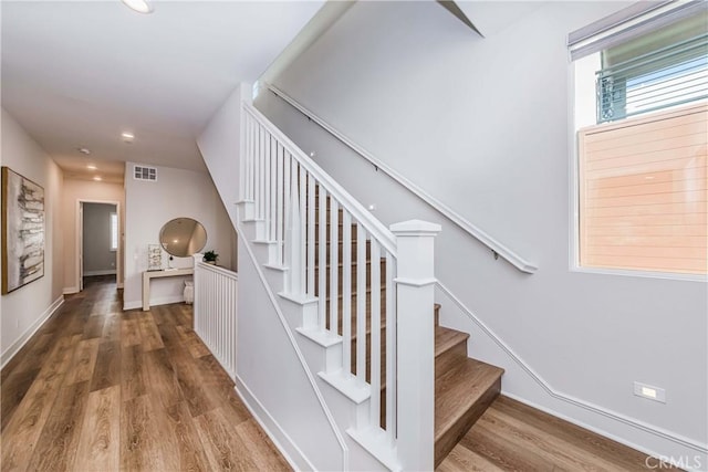 stairway with recessed lighting, wood finished floors, visible vents, and baseboards