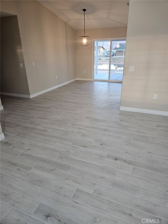 unfurnished dining area featuring baseboards and light wood-style floors