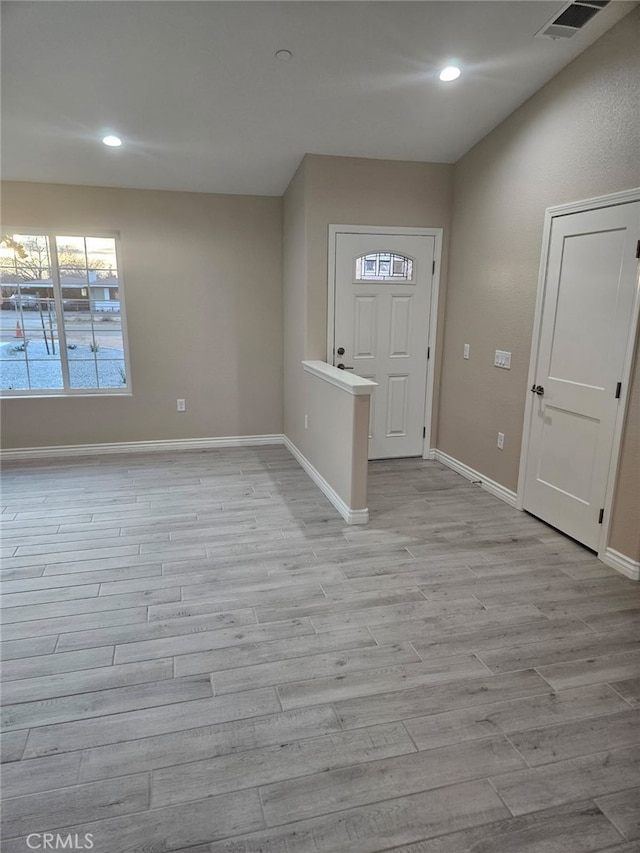 foyer featuring light wood-type flooring, visible vents, and baseboards