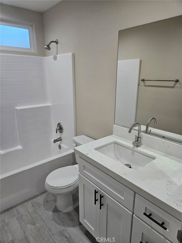 full bathroom with toilet, shower / washtub combination, wood finished floors, and vanity