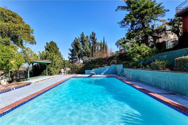 view of swimming pool featuring fence and a fenced in pool