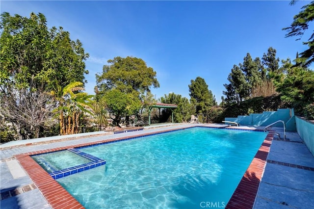 view of swimming pool featuring a patio, fence, and a pool with connected hot tub