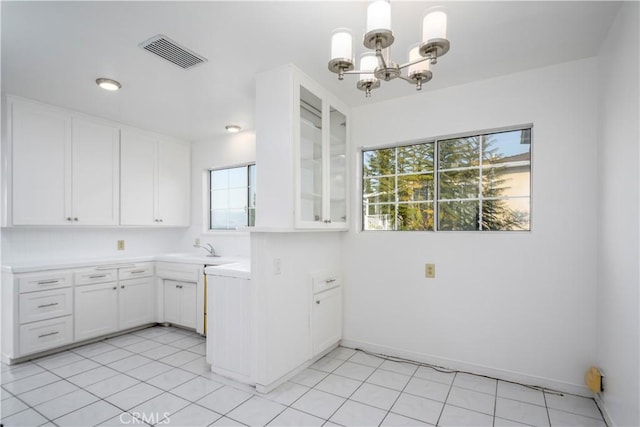 washroom with light tile patterned floors, baseboards, visible vents, a chandelier, and a sink