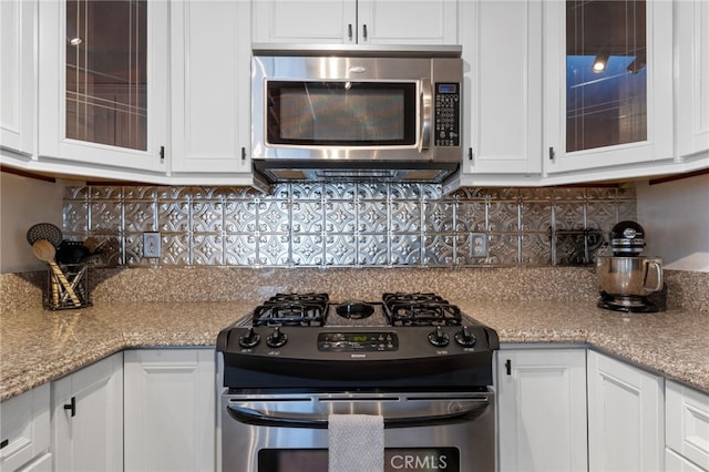 kitchen with appliances with stainless steel finishes, white cabinetry, and decorative backsplash