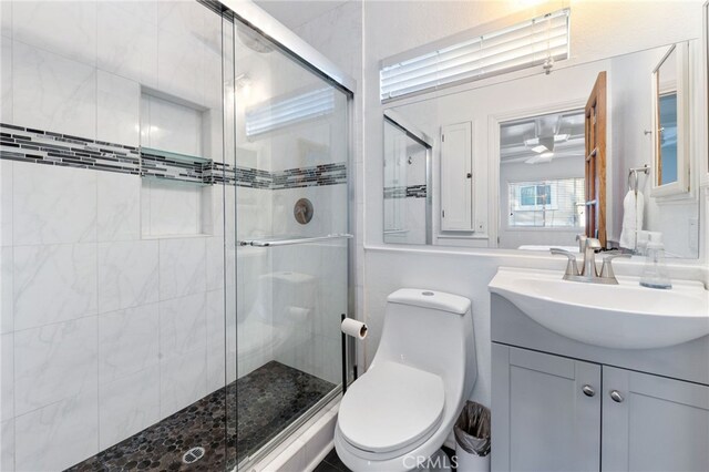 full bathroom with a shower stall, toilet, and vanity