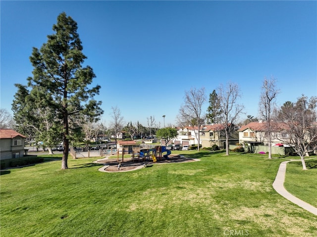 surrounding community with a residential view, playground community, and a yard