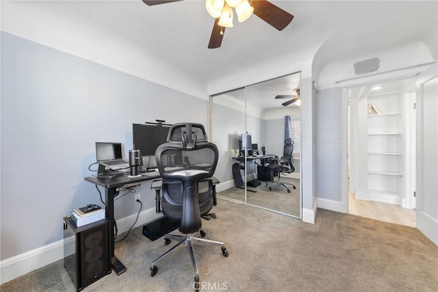 office space featuring carpet, visible vents, baseboards, and a ceiling fan