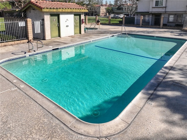 community pool featuring a patio area and fence