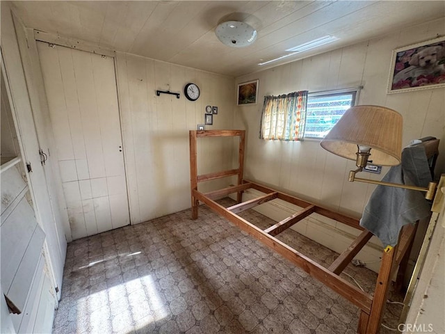 bedroom with wooden walls and tile patterned floors