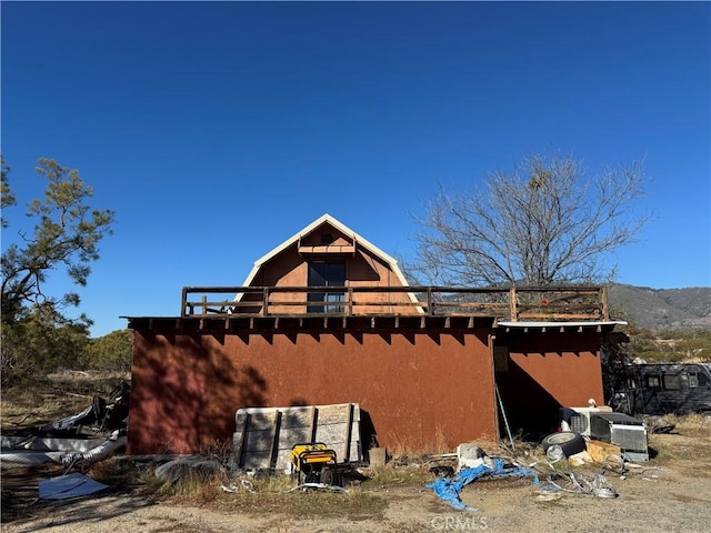 view of property exterior featuring a gambrel roof and stucco siding