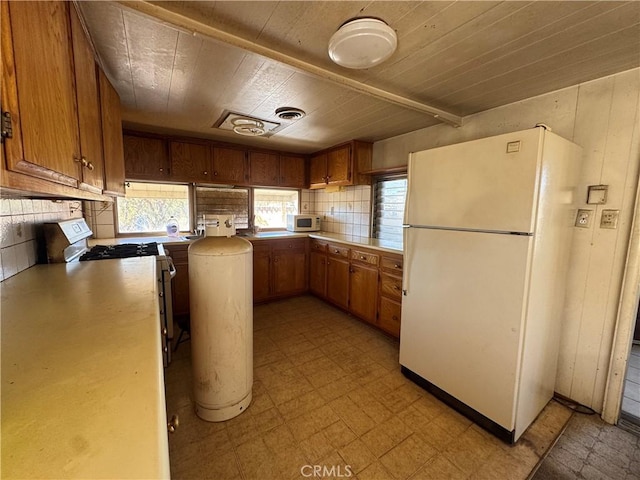 kitchen featuring white appliances, brown cabinets, and light floors