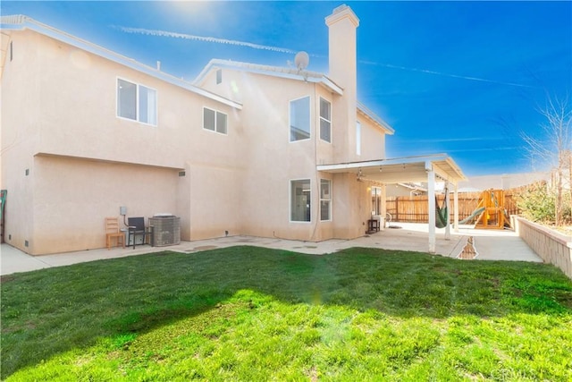 back of house featuring cooling unit, a fenced backyard, a lawn, stucco siding, and a patio area