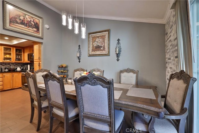 dining area featuring light wood-style floors and ornamental molding