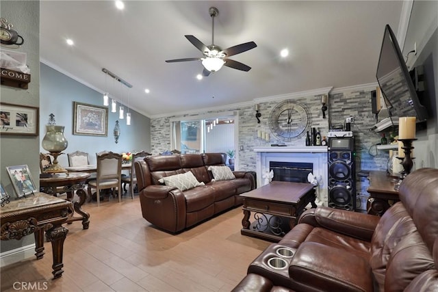 living room featuring vaulted ceiling, ornamental molding, wood finished floors, and a glass covered fireplace