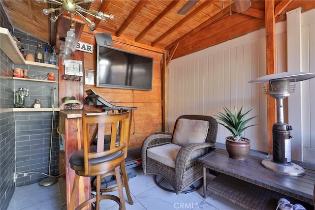 living area with vaulted ceiling with beams, wood ceiling, and wooden walls