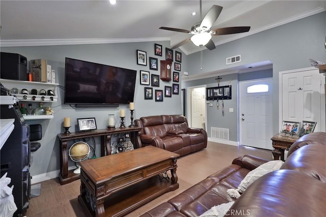 living area with lofted ceiling, wood finished floors, visible vents, and crown molding