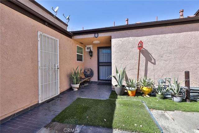 entrance to property with a patio and stucco siding