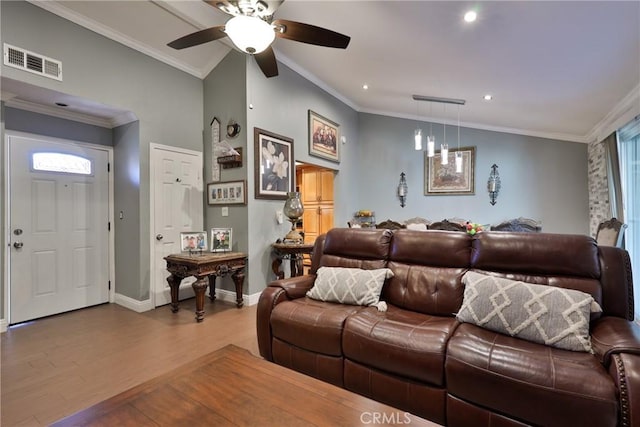 living area featuring baseboards, visible vents, crown molding, and wood finished floors